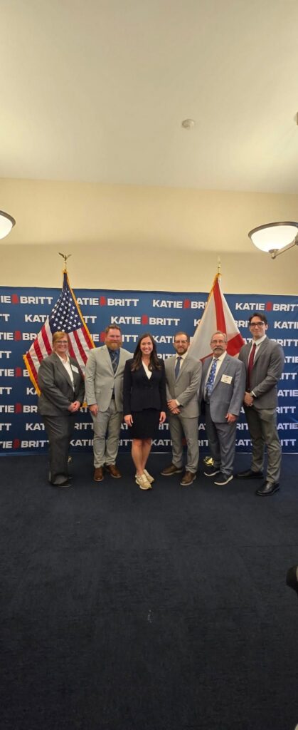 SEHPBA members pose in front of a Senator Katie Britt backdrop